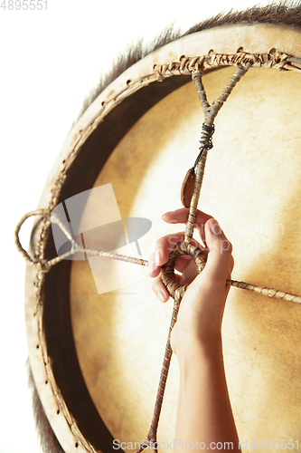 Image of A close up of hands playing the tambourine, percussion on white studio background