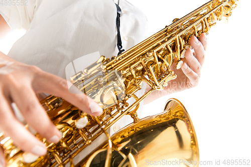 Image of Close up woman playing saxophone isolated on white studio background