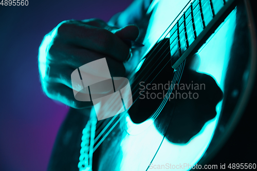 Image of Close up of guitarist hand playing guitar, copyspace, macro shot