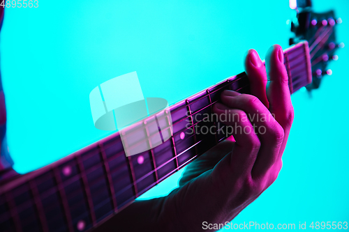 Image of Close up of guitarist hand playing guitar, copyspace, macro shot