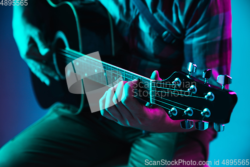 Image of Close up of guitarist hand playing guitar, copyspace, macro shot