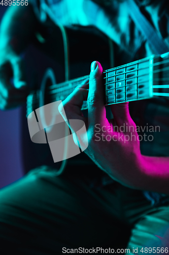 Image of Close up of guitarist hand playing guitar, copyspace, macro shot