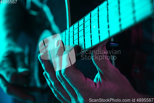 Image of Close up of guitarist hand playing guitar, copyspace, macro shot