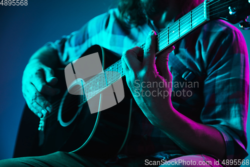 Image of Close up of guitarist hand playing guitar, copyspace, macro shot