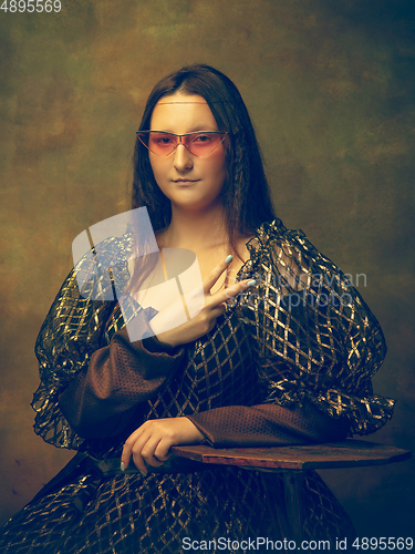 Image of Young woman as Mona Lisa on dark background. Retro style, comparison of eras concept.