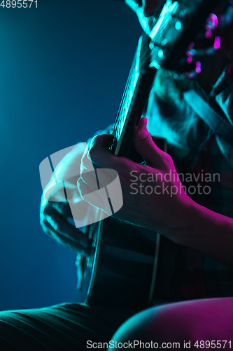 Image of Close up of guitarist hand playing guitar, copyspace, macro shot