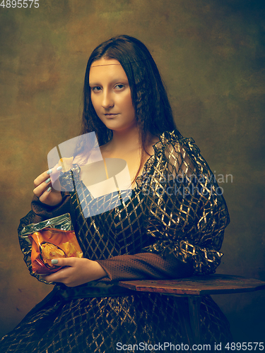 Image of Young woman as Mona Lisa on dark background. Retro style, comparison of eras concept.