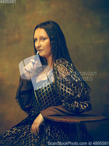 Image of Young woman as Mona Lisa on dark background. Retro style, comparison of eras concept.