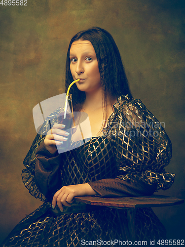 Image of Young woman as Mona Lisa on dark background. Retro style, comparison of eras concept.