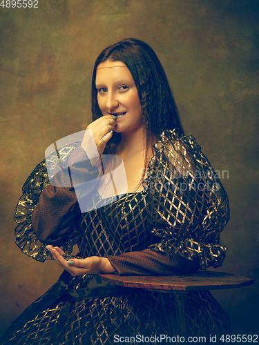 Image of Young woman as Mona Lisa on dark background. Retro style, comparison of eras concept.