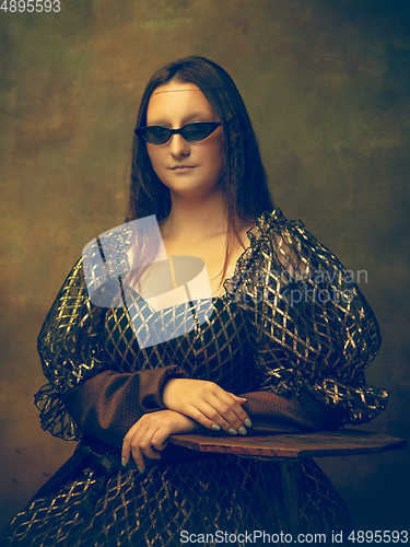 Image of Young woman as Mona Lisa on dark background. Retro style, comparison of eras concept.