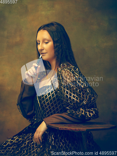 Image of Young woman as Mona Lisa on dark background. Retro style, comparison of eras concept.