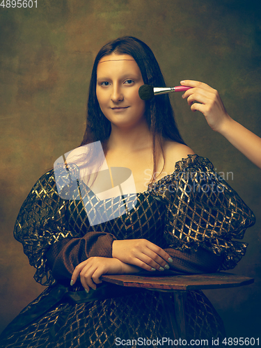 Image of Young woman as Mona Lisa on dark background. Retro style, comparison of eras concept.