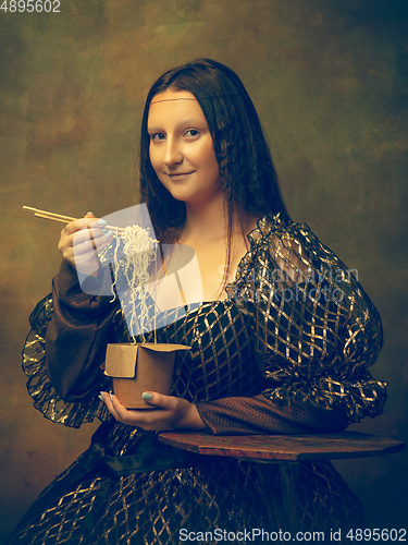 Image of Young woman as Mona Lisa on dark background. Retro style, comparison of eras concept.