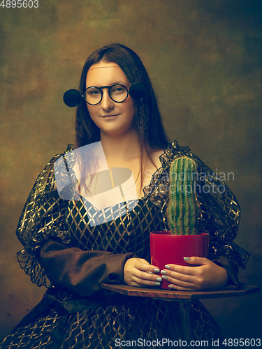Image of Young woman as Mona Lisa on dark background. Retro style, comparison of eras concept.
