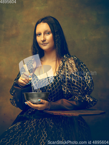 Image of Young woman as Mona Lisa on dark background. Retro style, comparison of eras concept.