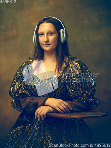 Image of Young woman as Mona Lisa on dark background. Retro style, comparison of eras concept.