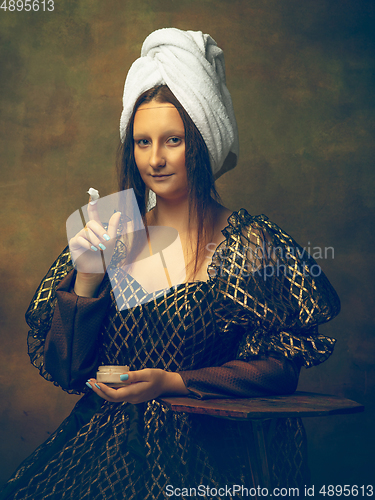 Image of Young woman as Mona Lisa on dark background. Retro style, comparison of eras concept.