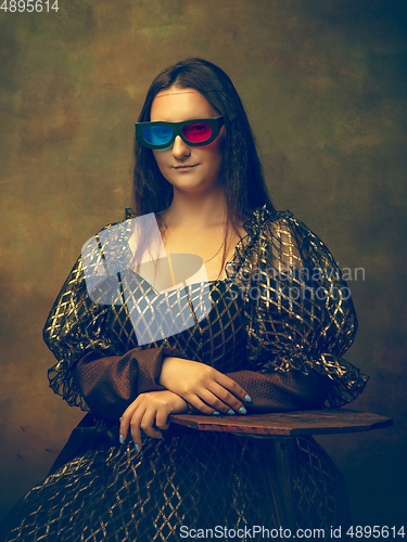 Image of Young woman as Mona Lisa on dark background. Retro style, comparison of eras concept.