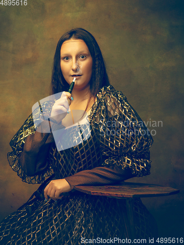 Image of Young woman as Mona Lisa on dark background. Retro style, comparison of eras concept.