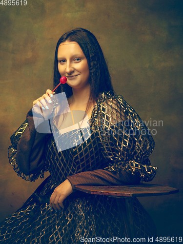 Image of Young woman as Mona Lisa on dark background. Retro style, comparison of eras concept.