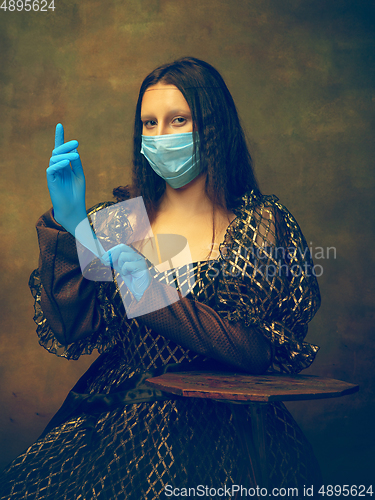 Image of Young woman as Mona Lisa on dark background. Retro style, comparison of eras concept.