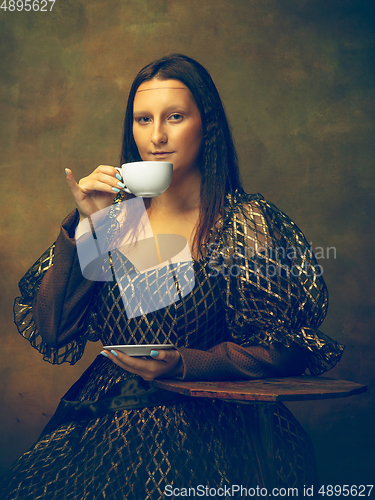 Image of Young woman as Mona Lisa on dark background. Retro style, comparison of eras concept.