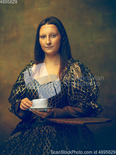 Image of Young woman as Mona Lisa on dark background. Retro style, comparison of eras concept.