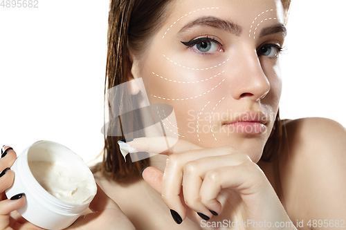 Image of Youth secrets. Beautiful young woman over white background. Cosmetics and makeup, lifting and aging concept.