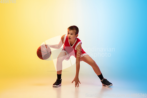 Image of Full length portrait of a young basketball player with ball on gradient background