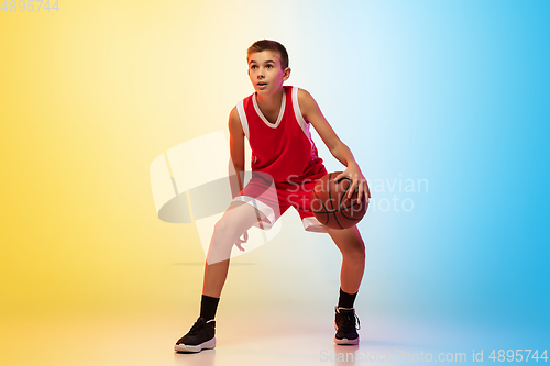 Image of Full length portrait of a young basketball player with ball on gradient background