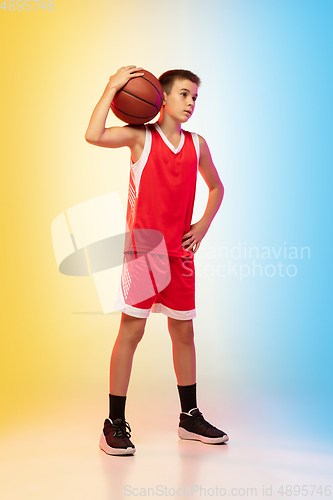 Image of Full length portrait of a young basketball player with ball on gradient background