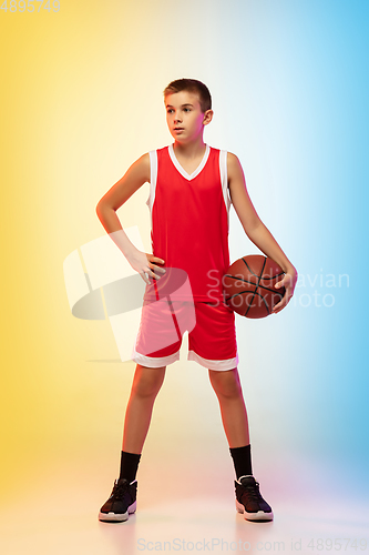 Image of Full length portrait of a young basketball player with ball on gradient background