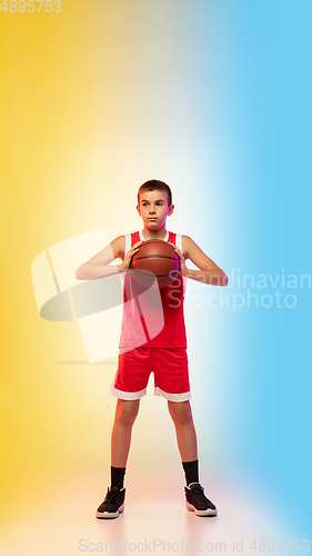 Image of Full length portrait of a young basketball player with ball on gradient background