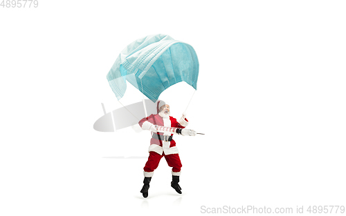 Image of Santa Claus flying on huge face mask like on balloon isolated on white background