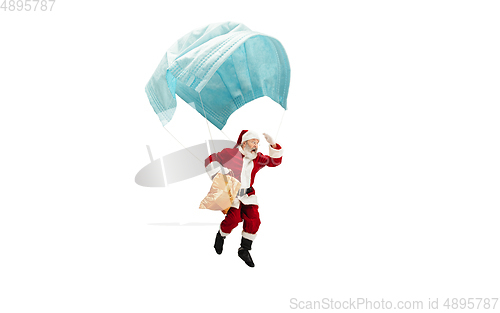 Image of Santa Claus flying on huge face mask like on balloon isolated on white background