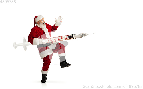 Image of Santa Claus holding huge vaccine against COVID like Christmas gift isolated on white background