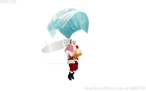 Image of Santa Claus flying on huge face mask like on balloon isolated on white background