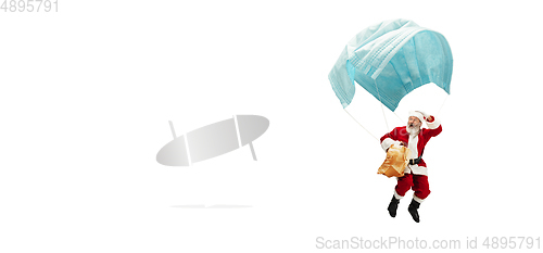 Image of Santa Claus flying on huge face mask like on balloon isolated on white background