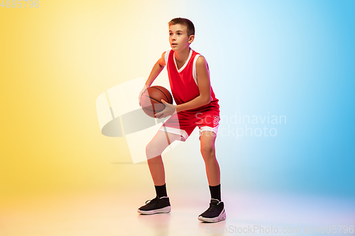 Image of Full length portrait of a young basketball player with ball on gradient background