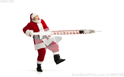 Image of Santa Claus holding huge vaccine against COVID like Christmas gift isolated on white background