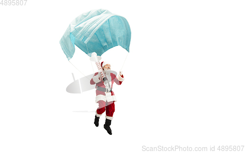 Image of Santa Claus flying on huge face mask like on balloon isolated on white background