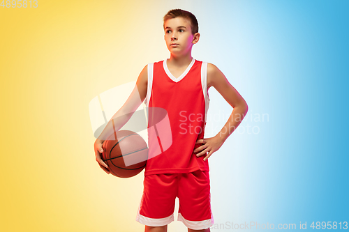 Image of Full length portrait of a young basketball player with ball on gradient background