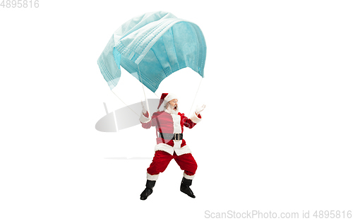 Image of Santa Claus flying on huge face mask like on balloon isolated on white background