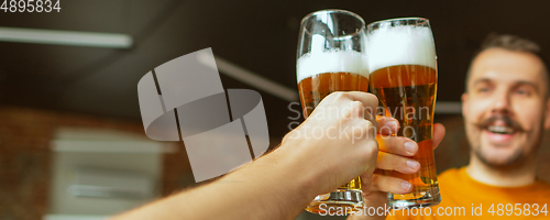 Image of Hands of young friends, colleagues during beer drinking, having fun, laughting and celebrating together. Flyer with copyspace