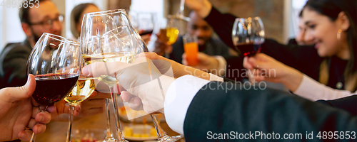 Image of Hands of young friends, colleagues during beer drinking, having fun, laughting and celebrating together. Flyer with copyspace