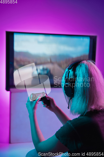 Image of Back view shot of professional gamer playing online video game on his personal computer.