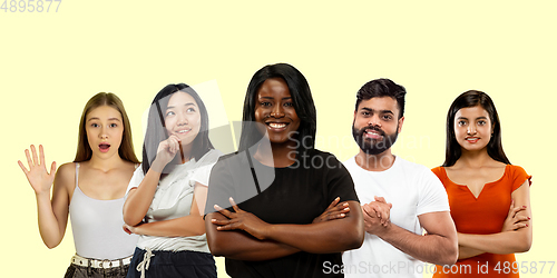 Image of Group portrait of emotional people on yellow studio background