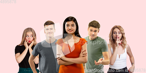 Image of Group portrait of emotional people on coral pink studio background