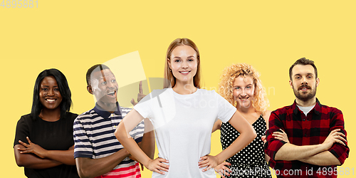 Image of Group portrait of emotional people on yellow studio background